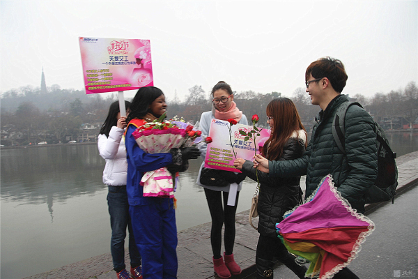 外籍女工西湖邊“關(guān)愛(ài)女工”行為體驗(yàn) 游人的熱情擁抱累得她胳膊抬不起來(lái)